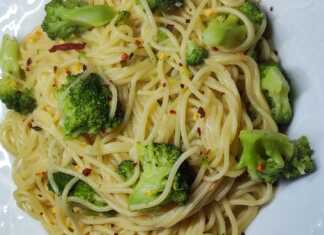 Ένα μπολ με ζεστό σπαγγέτι με μπρόκολο και σκόρδο, γαρνιρισμένο με φρέσκα μυρωδικά.