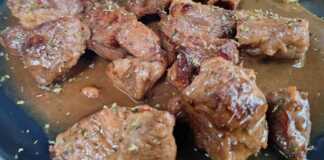 Μια χοιρινή τηγανιά με λεμόνι και κρασί στο τηγάνι, με πλούσια, δεμένη σάλτσα