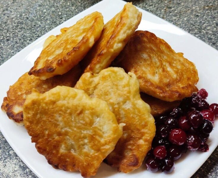 Μια πιατέλα με χρυσαφένιες και αφράτες μηλοτηγανίτες χωρίς μαγιά