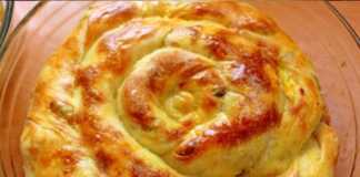 Η μορφοποιημένη ζύμη για τυρόπιτα σε σχήμα σαλιγκαριού, μέσα στο ταψί