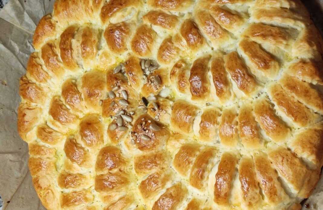 Μια στρογγυλή πιατέλα με φρεσκοψημένο, αφράτο τυρόψωμο, έτοιμο για σερβίρισμα