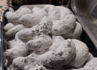 Αφράτοι Κουραμπιέδες με άχνη ζάχαρη και ολόκληρα αμύγδαλα.