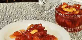 Γλυκό του Κουταλιού Κυδώνι σε βάζο, με κομμάτια κυδωνιού και ολόκληρα αμύγδαλα.