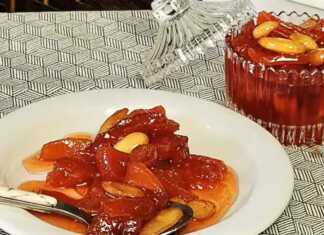 Γλυκό του Κουταλιού Κυδώνι σε βάζο, με κομμάτια κυδωνιού και ολόκληρα αμύγδαλα.