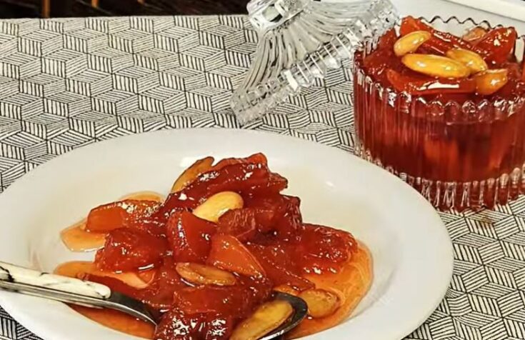 Γλυκό του Κουταλιού Κυδώνι σε βάζο, με κομμάτια κυδωνιού και ολόκληρα αμύγδαλα.