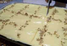 Καρυδόπιτα με Κρέμα κομμένη σε κομμάτια, με επικάλυψη κρέμας και καρύδια.