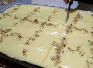 Καρυδόπιτα με Κρέμα κομμένη σε κομμάτια, με επικάλυψη κρέμας και καρύδια.