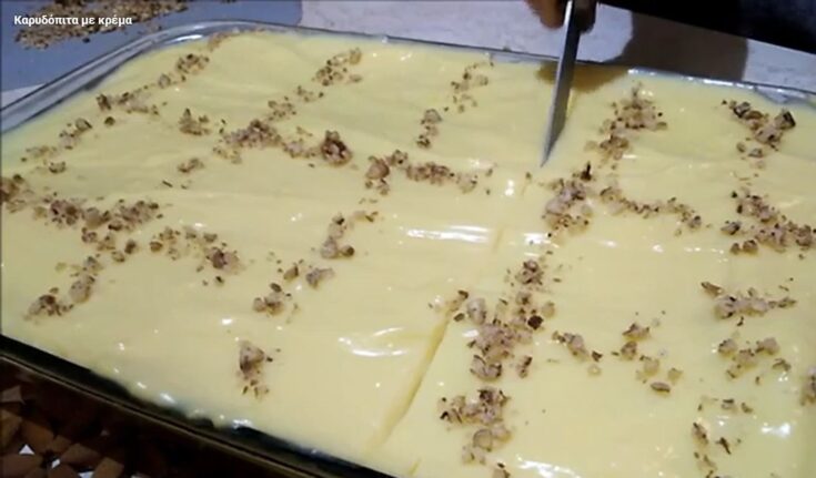 Καρυδόπιτα με Κρέμα κομμένη σε κομμάτια, με επικάλυψη κρέμας και καρύδια.