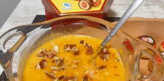 Ζεστή κρέμα κολοκύθας σε μπολ, πασπαλισμένη με καρύδια και κανέλα.