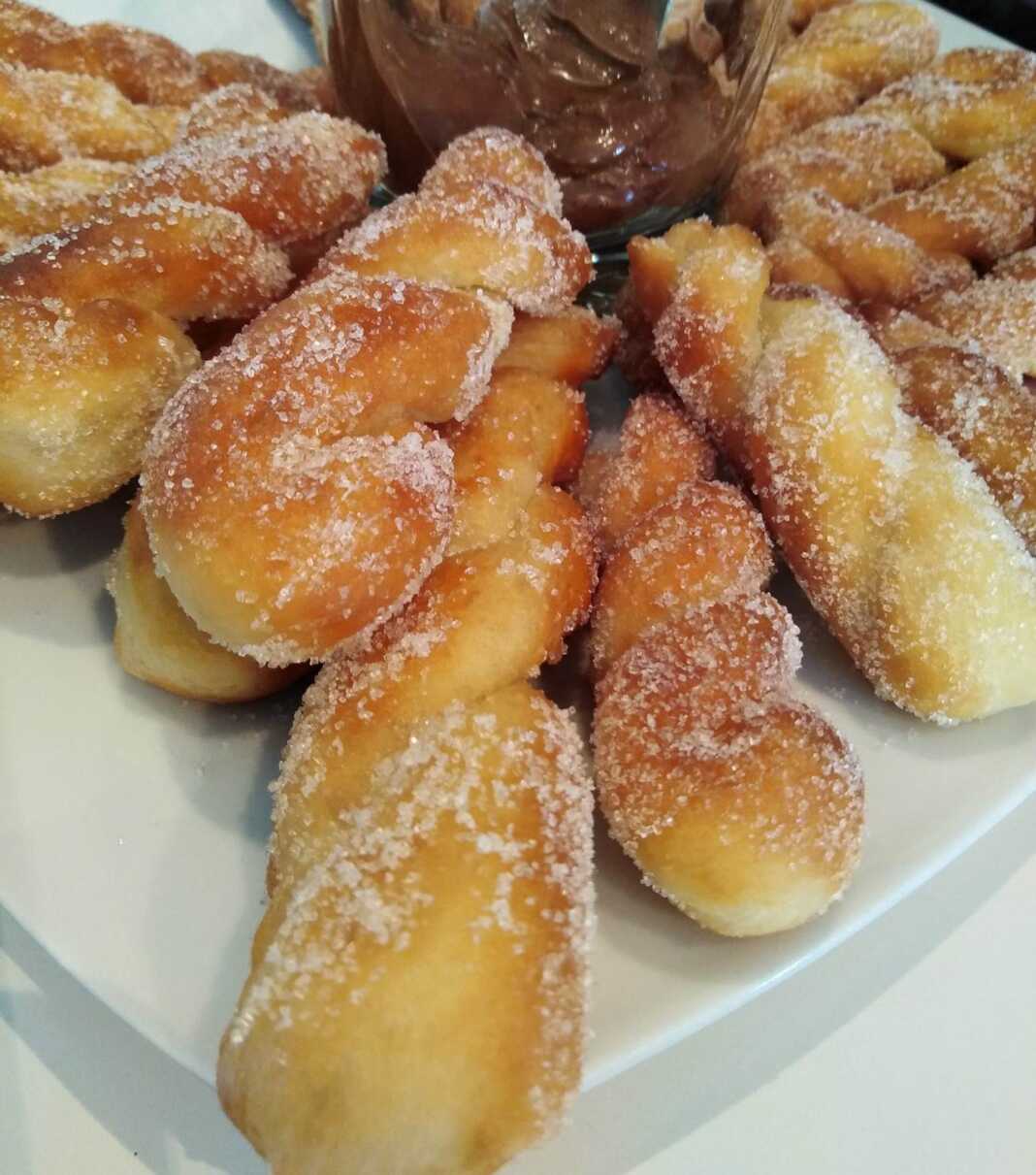 Λουκουμάδες Αφράτοι πασπαλισμένοι με ζάχαρη σε πιάτο.