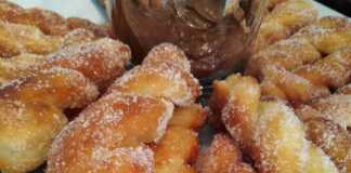 Λουκουμάδες Αφράτοι πασπαλισμένοι με ζάχαρη σε πιάτο.