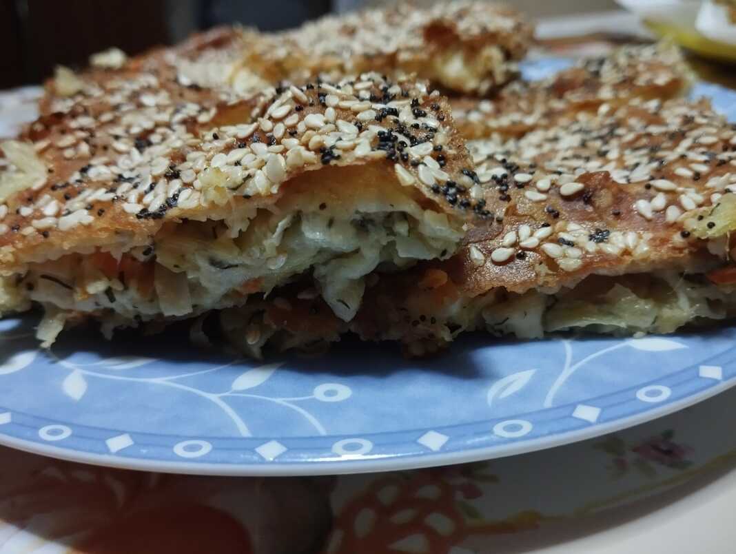 Κομμάτι από πρασοτυρόπιτα με εμφανή τα τραγανά φύλλα και την ζουμερή γέμιση