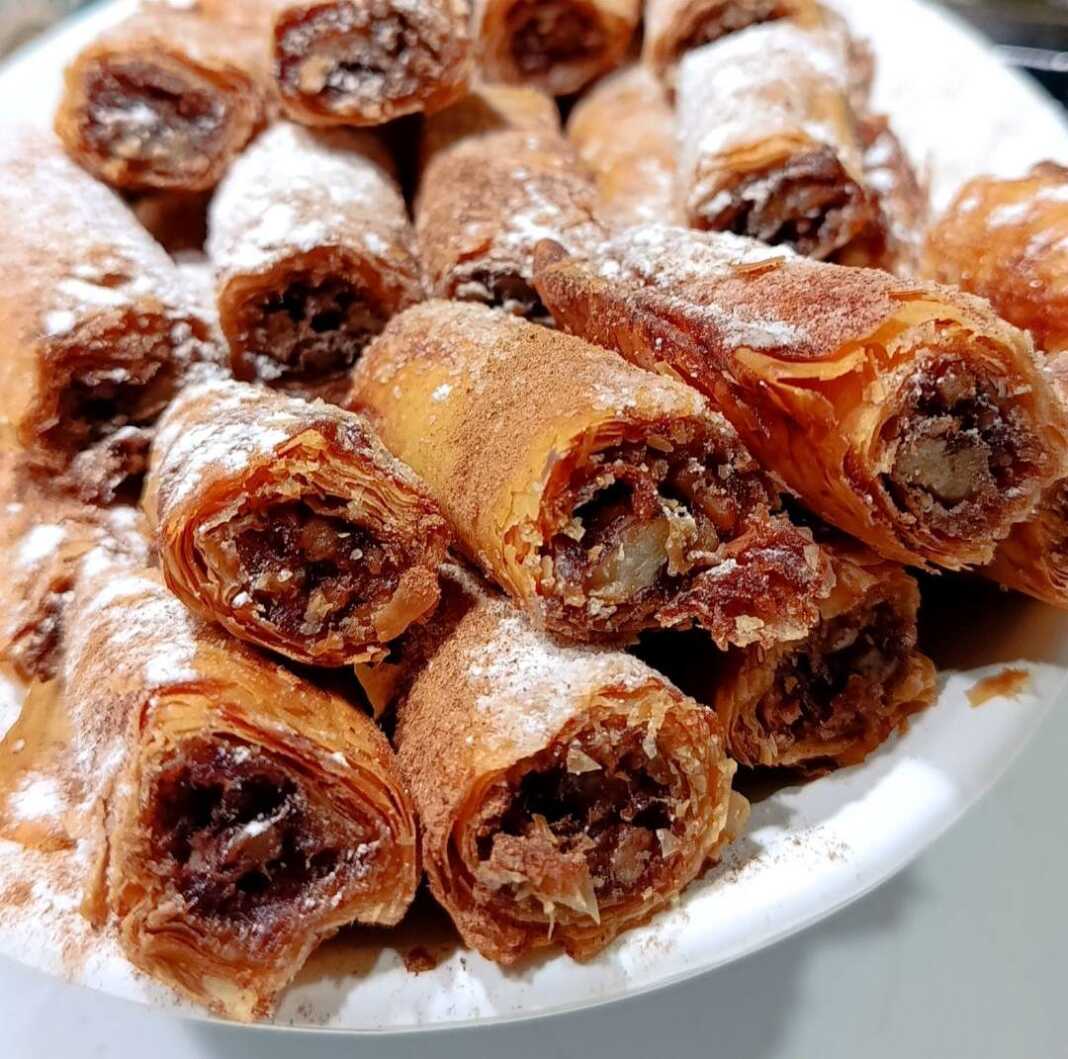 Ρολάκια με Γέμιση Μήλου σε φύλλο κρούστας, πασπαλισμένα με άχνη και κανέλα.