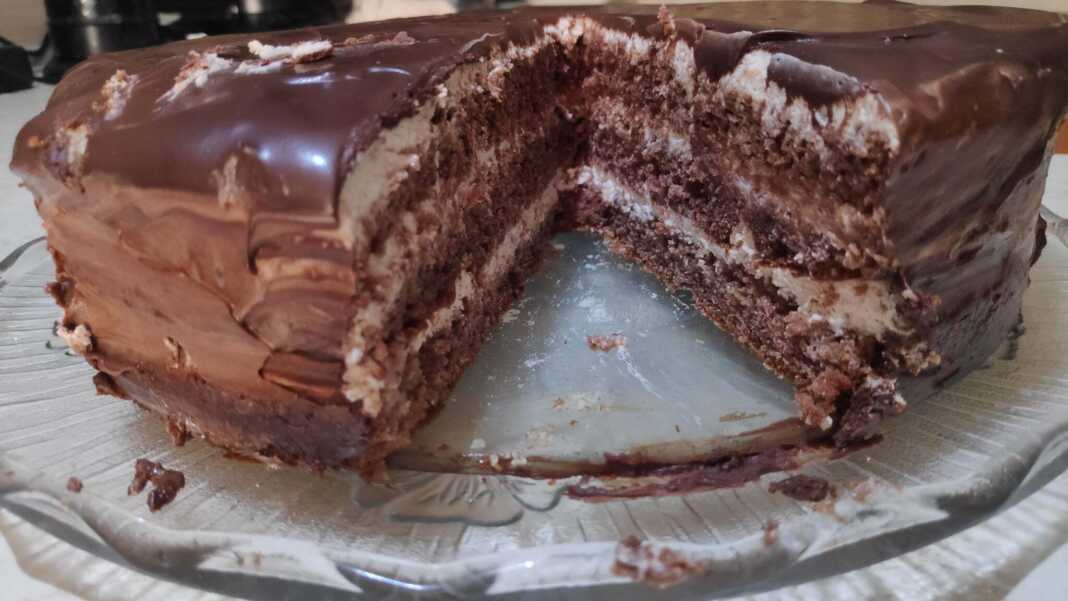 Σοκολατένια Τούρτα με επικάλυψη γκανάζ σοκολάτας, κομμένη σε τρία στρώματα.
