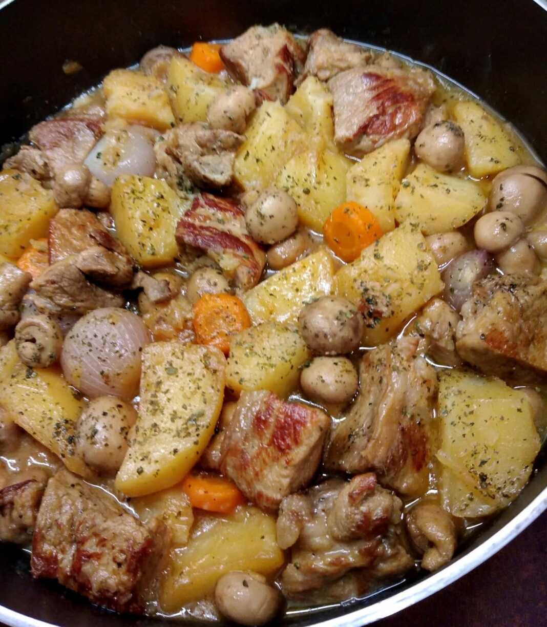 Χοιρινό με πατάτες και μανιτάρια στην κατσαρόλα, με πλούσια σάλτσα, έτοιμο για σερβίρισμα.