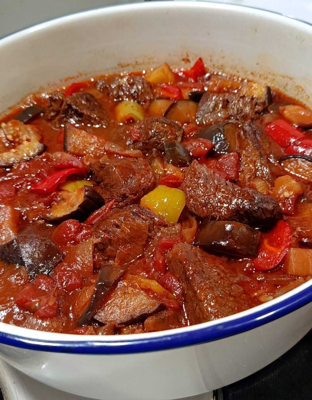 Μοσχάρι κοκκινιστό με μελιτζάνες και πιπεριές σε πιάτο, σερβιρισμένο με ρύζι ή πατάτες.