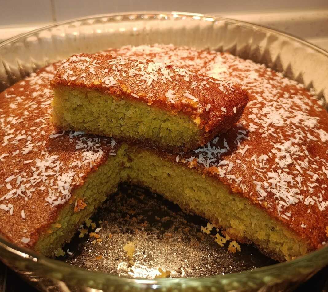 Κομμάτια από σιροπιαστό κέικ με πορτοκάλι και ινδοκάρυδο πασπαλισμένα με νιφάδες καρύδας σε πιατέλα