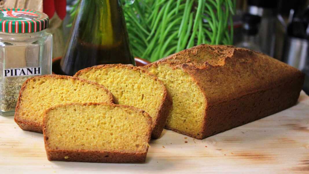 Ψωμί από καλαμποκάλευρο, κομμένο σε φέτες, με κρούστα και αφράτο εσωτερικό πάνω σε ξύλινη επιφάνεια