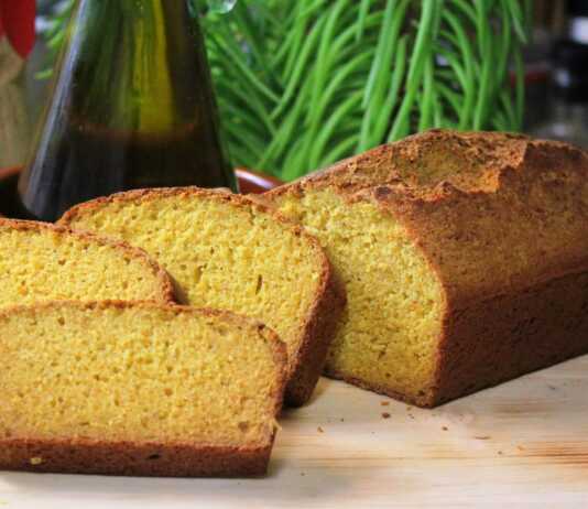 Ψωμί από καλαμποκάλευρο, κομμένο σε φέτες, με κρούστα και αφράτο εσωτερικό πάνω σε ξύλινη επιφάνεια