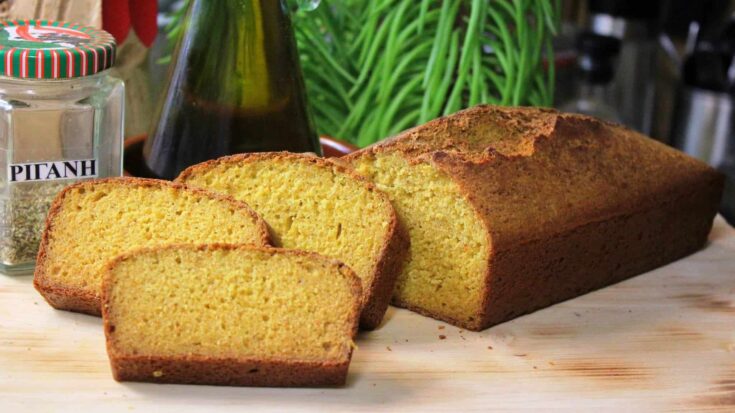 Ψωμί από καλαμποκάλευρο, κομμένο σε φέτες, με κρούστα και αφράτο εσωτερικό πάνω σε ξύλινη επιφάνεια