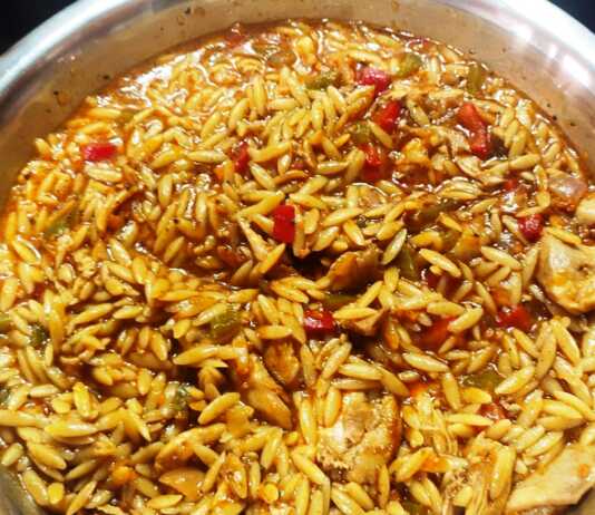 Κριθαρότο κοτόπουλο κοκκινιστό σε πιάτο, πασπαλισμένο με τριμμένο πεκορίνο