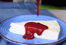 Κρεμώδες Γλυκό Ψυγείου με Καρύδα και Σάλτσα Βατόμουρο Κομμάτι από το γλυκό σε πιάτο, λούζεται στη σάλτσα βατόμουρο