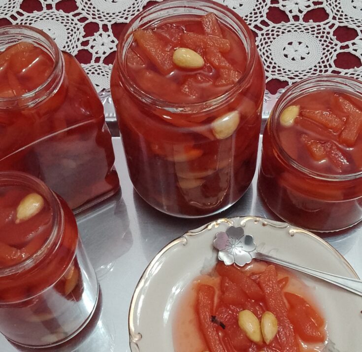 Γλυκό κουταλιού κυδώνι με κόκκινο χρώμα σε γυάλινο βάζο.