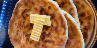 Στρογγυλό χατσαπούρι με τηγανισμένη αφράτη ζύμη και λιωμένη γέμιση τυριού, αλειμμένο με βούτυρο