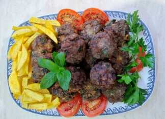 Πιάτο με χρυσαφένιους τηγανητούς κεφτέδες με ψιλοκομμένο δυόσμο και πατάτες τηγανητές