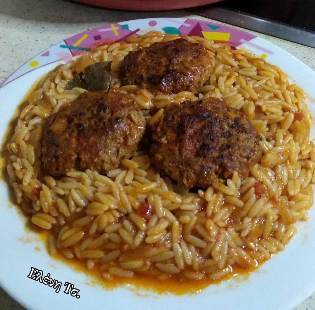 Ένα πιάτο με ζουμερά κεφτεδάκια και κριθαράκι σε πλούσια κόκκινη σάλτσα ντομάτας, μόλις βγαλμένο από το φούρνο