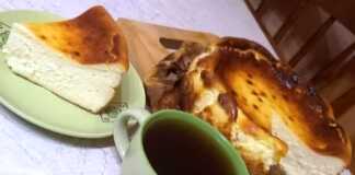 Κομμάτι από Τσιζκέικ Σαν Σεμπαστιάν με σκούρα καραμελωμένη επιφάνεια και κρεμώδες κίτρινο εσωτερικό, σερβιρισμένο με ένα φλιτζάνι καφέ