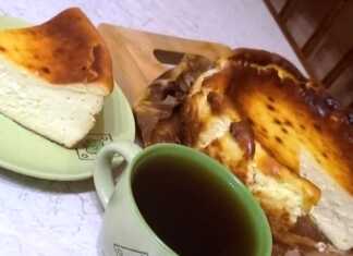 Κομμάτι από Τσιζκέικ Σαν Σεμπαστιάν με σκούρα καραμελωμένη επιφάνεια και κρεμώδες κίτρινο εσωτερικό, σερβιρισμένο με ένα φλιτζάνι καφέ