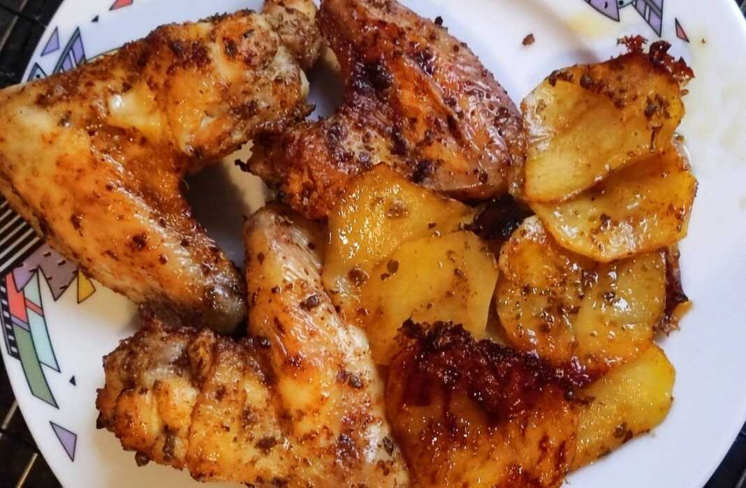 Χρυσαφένιες φτερούγες κοτόπουλου και λεμονάτες πατάτες ψημένες στο φούρνο, σερβιρισμένες σε ταψί