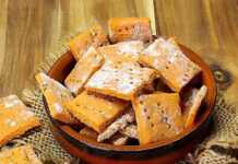 Τραγανά σπιτικά κρακεράκια σε τετράγωνα σχήματα, με κόκκινο χρώμα από την πάπρικα και τον κουρκουμά