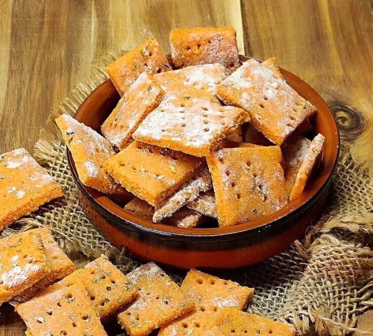 Τραγανά σπιτικά κρακεράκια σε τετράγωνα σχήματα, με κόκκινο χρώμα από την πάπρικα και τον κουρκουμά