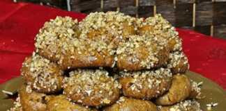 Πιατέλα γεμάτη με σιροπιασμένα Μελομακάρονα πασπαλισμένα με ψιλοκομμένο καρύδι και λιωμένο μέλι