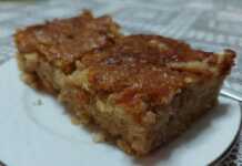 Κομμάτι μηλόπιτας που δείχνει το τριμμένο μήλο και την αφράτη υφή του κέικ.