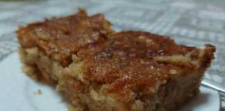 Κομμάτι μηλόπιτας που δείχνει το τριμμένο μήλο και την αφράτη υφή του κέικ.