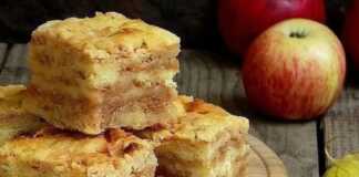 Κομμάτια από μια ζουμερή μηλόπιτα με διακρινόμενες στρώσεις από την τριμμένη μήλα και τη βάση σιμιγδαλιού