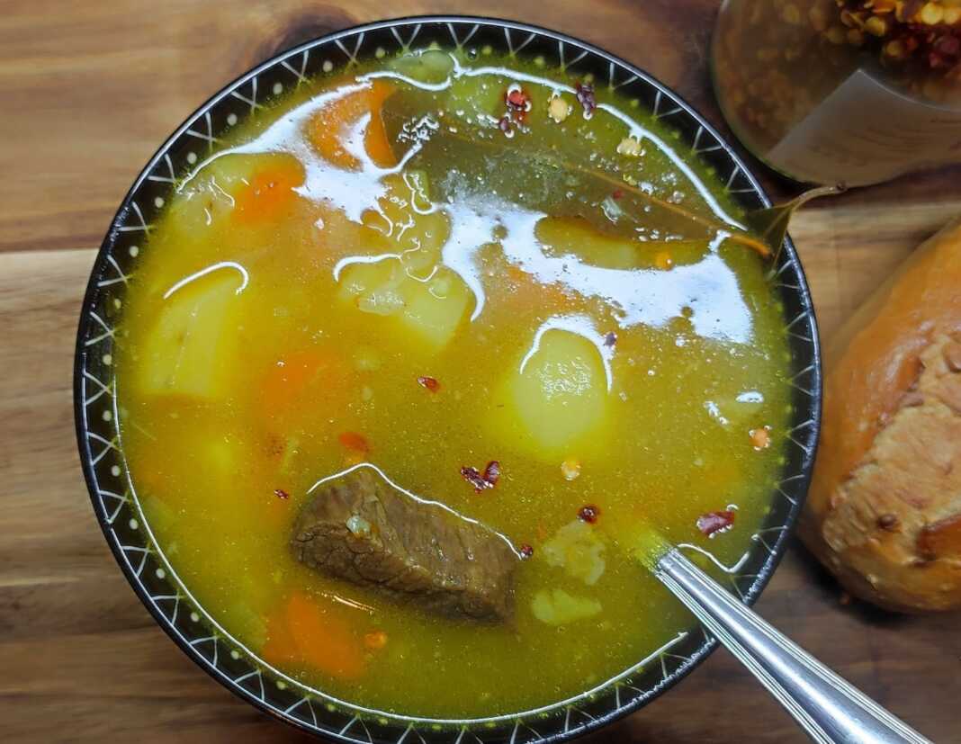 Ζεστή μοσχαρόσουπα με κομμάτια μοσχαριού, καρότα, πατάτες και σέλινο, σερβιρισμένη σε μπολ με λίγο πιπέρι από πάνω