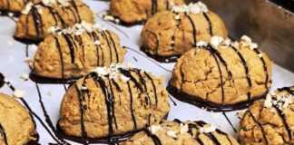 Τραγανά στρογγυλά μπισκότα με ταχίνι και κανταΐφι, βουτηγμένα στη λιωμένη μαύρη κουβερτούρα και πασπαλισμένα με τριμμένα φουντούκια