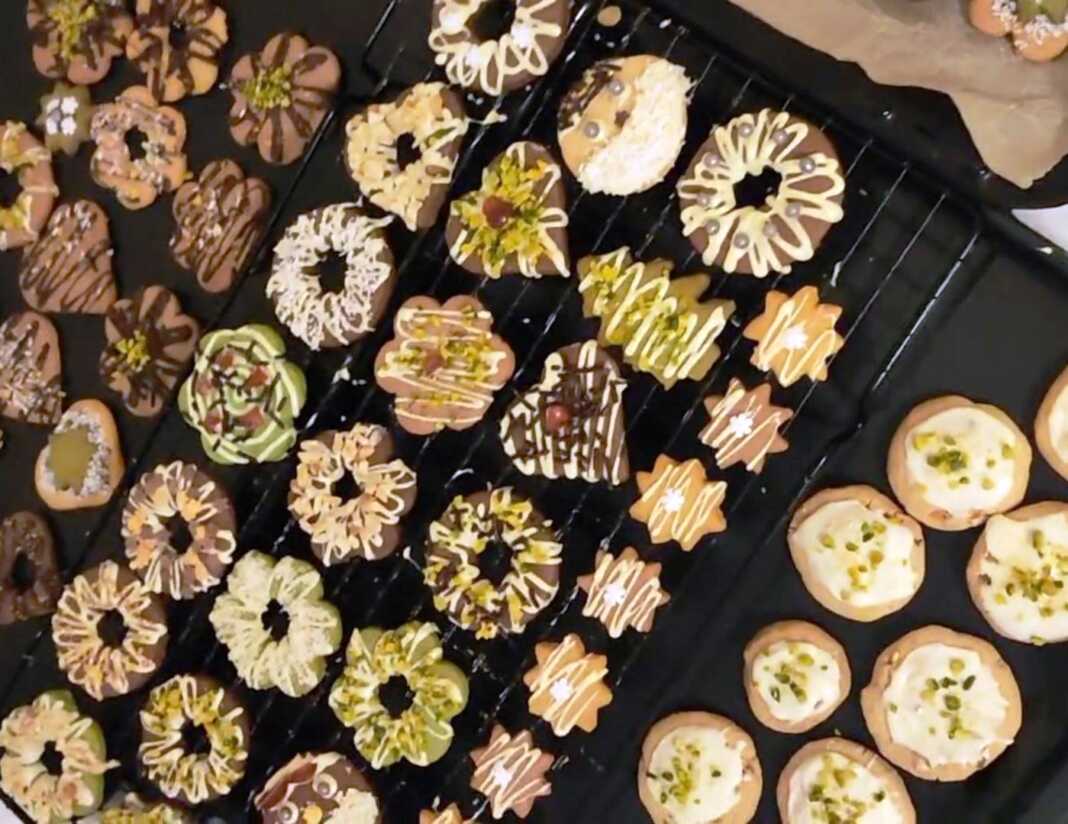 Ποικιλία από πολύχρωμα Χριστουγεννιάτικα Μπισκοτάκια διακοσμημένα με σοκολάτα και ξηρούς καρπούς σε χριστουγεννιάτικο φόντο