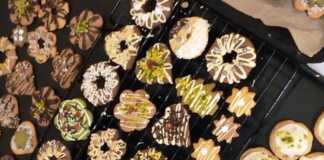 Ποικιλία από πολύχρωμα Χριστουγεννιάτικα Μπισκοτάκια διακοσμημένα με σοκολάτα και ξηρούς καρπούς σε χριστουγεννιάτικο φόντο