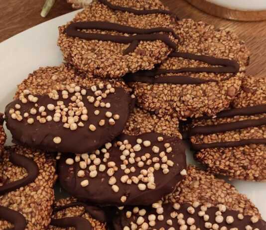 Στρογγυλά μπισκοτοπαστελάκια με σουσάμι και λιναρόσπορο, μερικά από τα οποία είναι βουτηγμένα σε πικρή σοκολάτα