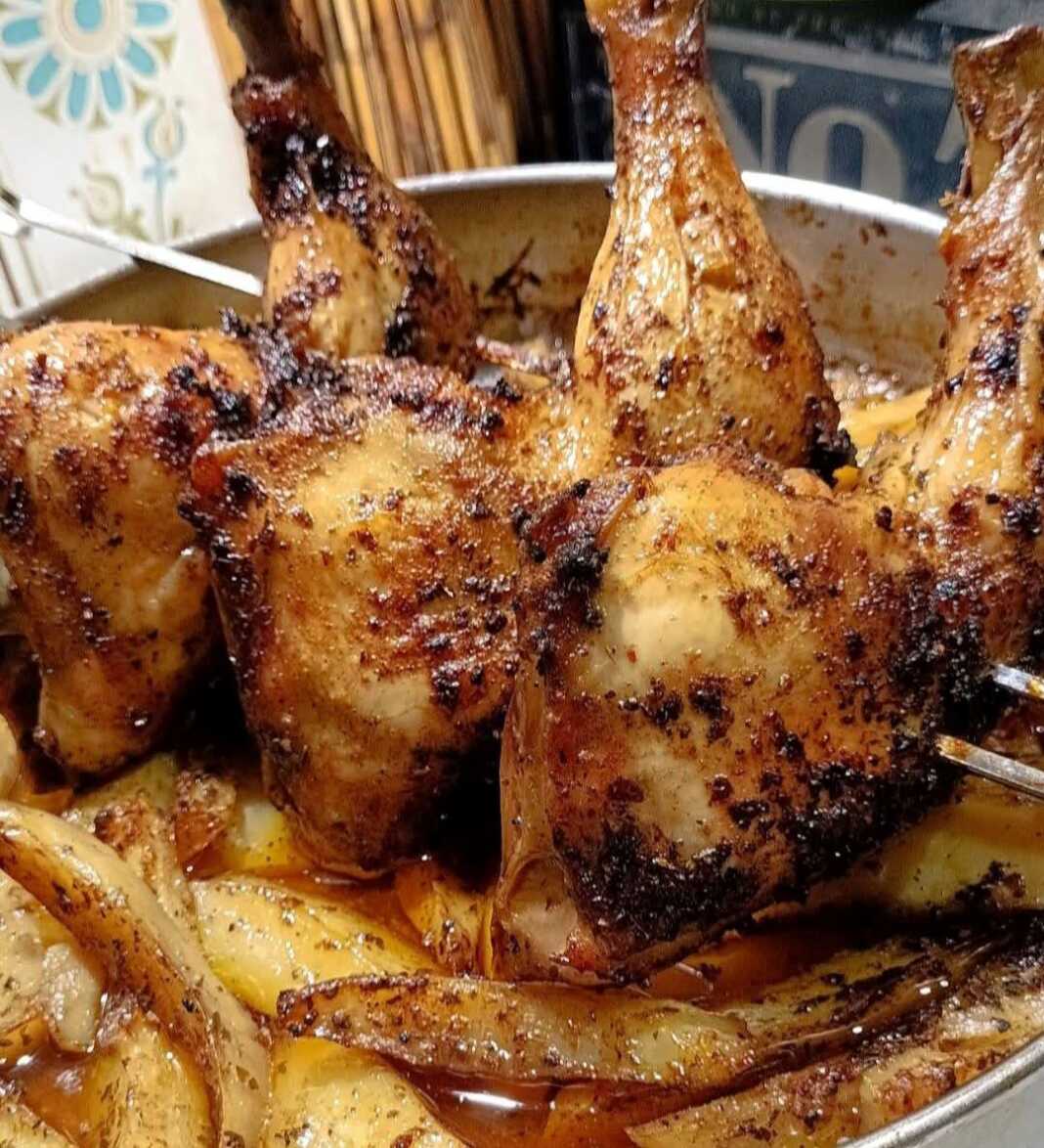 Τρία ζουμερά μπουτάκια κοτόπουλο σε σούβλα φούρνου, καλοψημένα με πάπρικα, τοποθετημένα πάνω από κυδωνάτες πατάτες