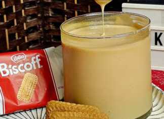 Πλούσια και ρευστή πραλίνα Lotus με λευκή σοκολάτα σερβιρισμένη σε γυάλινο βάζο με μπισκότα Lotus στο φόντο