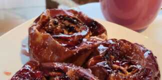 Μήλα Ψητά με Κόκκινο Κρασί και Κανέλα Τέσσερα σιγοψημένα μήλα στο ταψί, κομμένα στη μέση και γεμισμένα με καρύδια και σταφίδες, με σιρόπι από κόκκινο κρασί και κανέλα