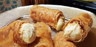 Χρυσαφένια σιροπιαστά ρολάκια κρούστας κορνέ με κρέμα πατισερί, παρουσιασμένα σε πιατέλα