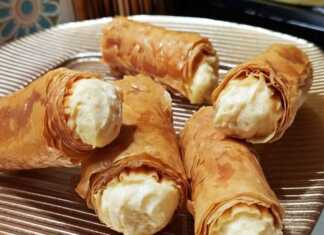 Χρυσαφένια σιροπιαστά ρολάκια κρούστας κορνέ με κρέμα πατισερί, παρουσιασμένα σε πιατέλα