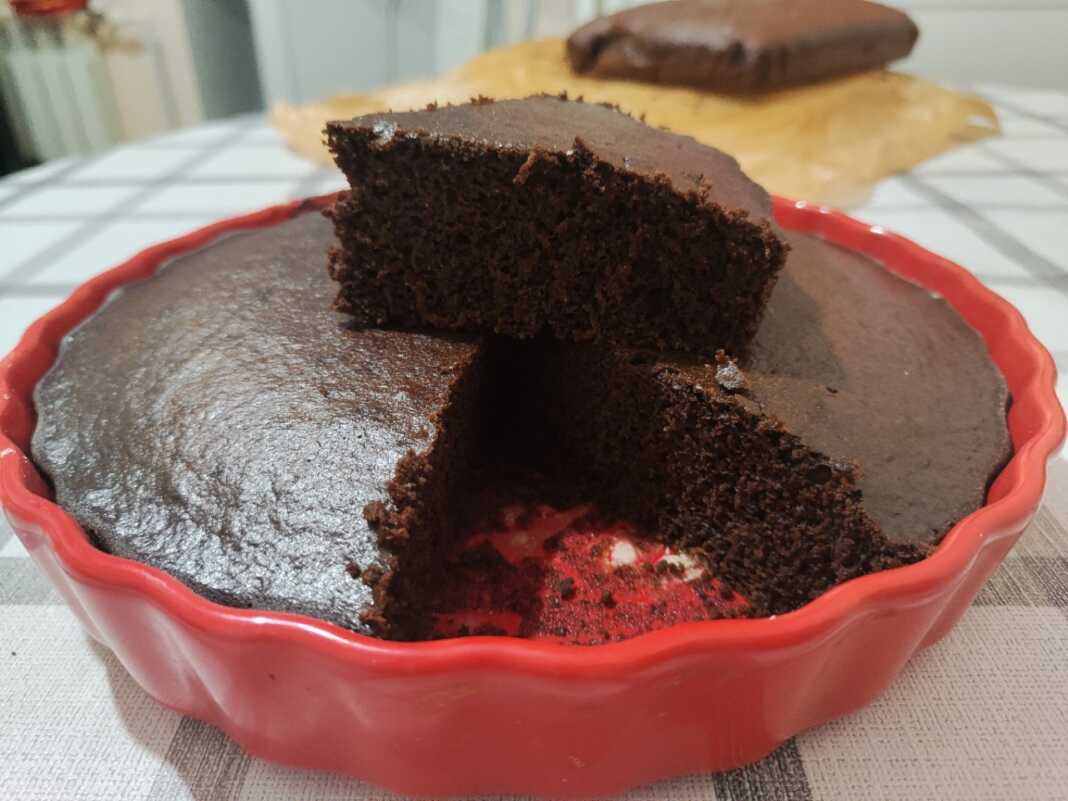Ένα πλούσιο και μαλακό Κέικ Σοκολατόπιτα με κακάο, κομμένο σε κομμάτια και πασπαλισμένο με άχνη ζάχαρη